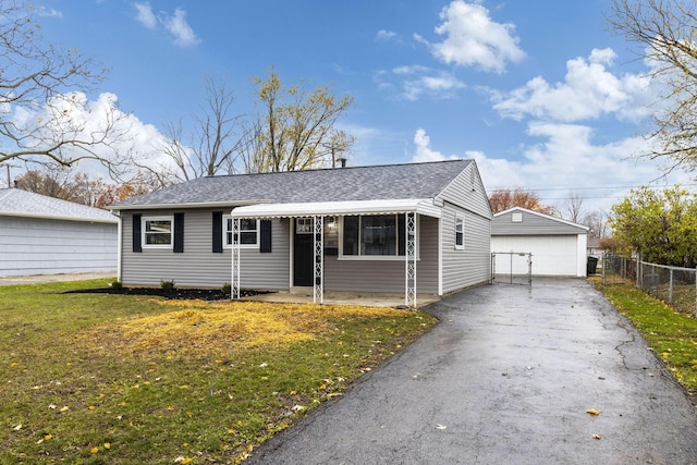 view of front of home featuring a front yard, an outdoor structure, and a garage