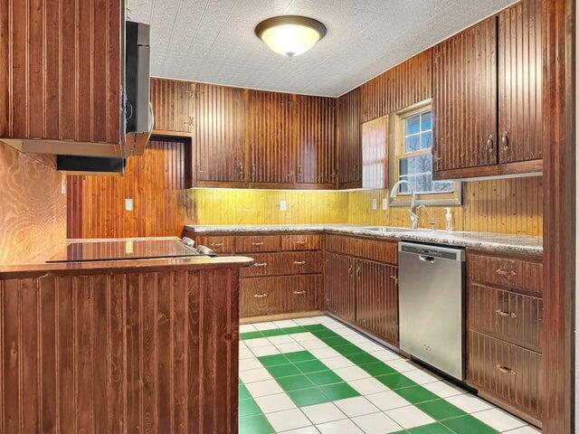 kitchen featuring stainless steel dishwasher, sink, black electric cooktop, and a textured ceiling