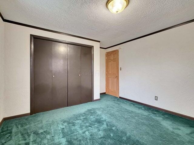 unfurnished bedroom featuring dark carpet, a textured ceiling, and a closet