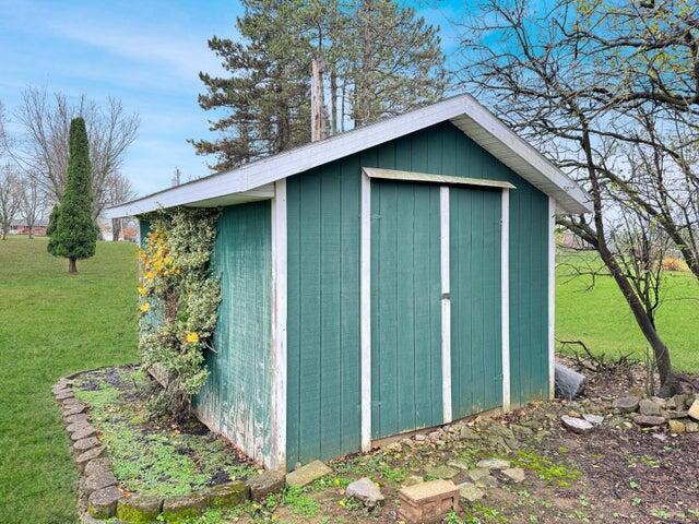 view of outbuilding featuring a lawn