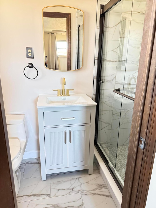 bathroom featuring vanity, toilet, and a shower with shower door