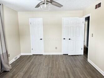 unfurnished bedroom with ceiling fan and dark hardwood / wood-style floors