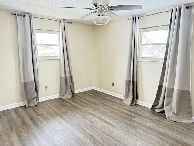 unfurnished room featuring ceiling fan, wood-type flooring, and a textured ceiling