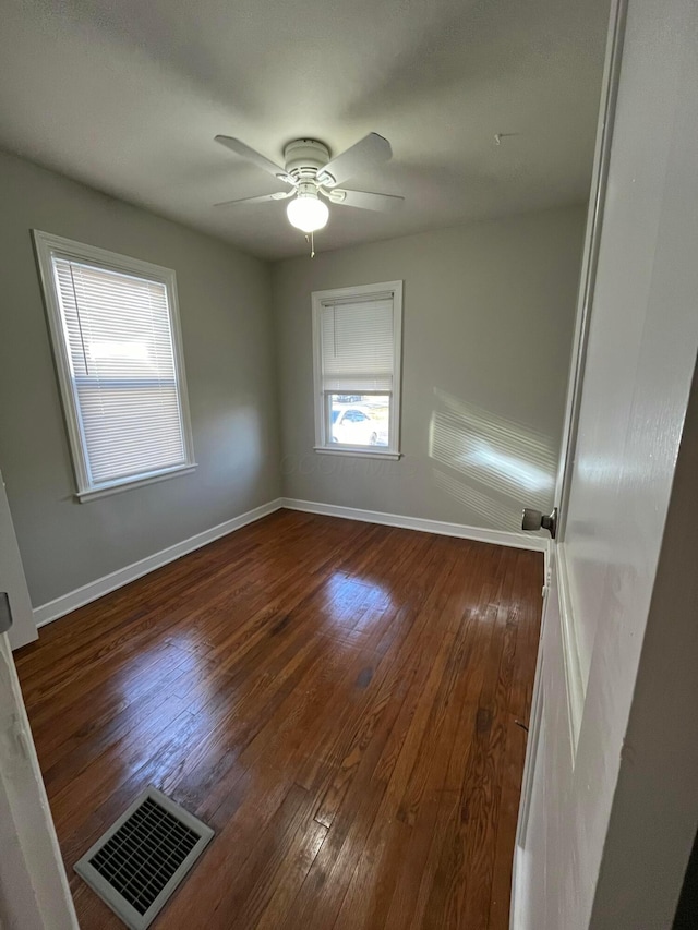 unfurnished room with dark hardwood / wood-style floors and ceiling fan