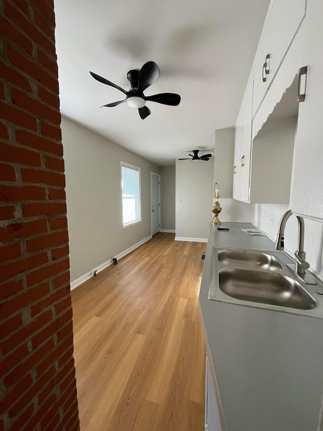 kitchen with sink, white cabinets, and light hardwood / wood-style floors