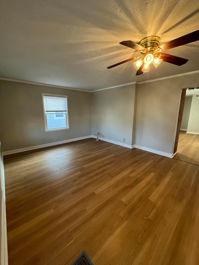 unfurnished room with ceiling fan, wood-type flooring, a textured ceiling, and ornamental molding