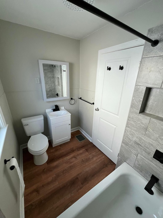 bathroom with wood-type flooring, vanity, and toilet