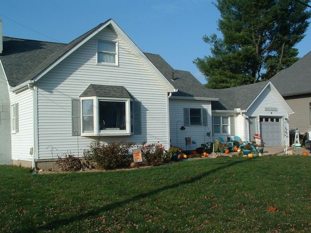 rear view of house with a lawn and a garage