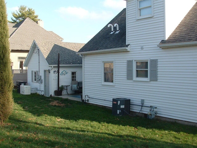 rear view of house with a yard and central AC