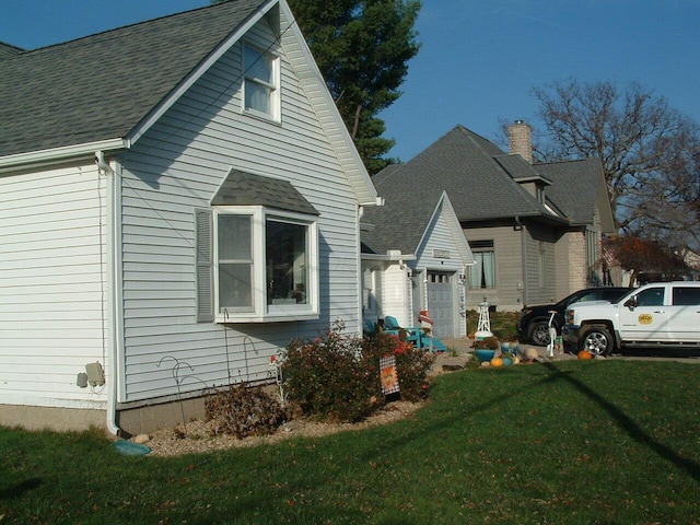 view of side of property featuring a garage and a yard