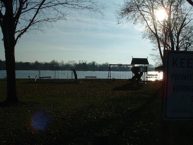 view of yard with a playground and a water view