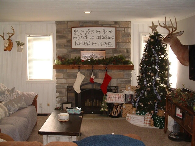 carpeted living room with wood walls and a fireplace