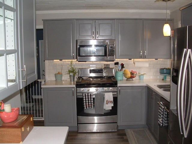 kitchen with pendant lighting, dark hardwood / wood-style floors, gray cabinets, and appliances with stainless steel finishes