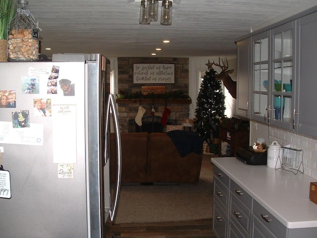 kitchen featuring decorative backsplash, dark hardwood / wood-style floors, stainless steel refrigerator, and gray cabinetry