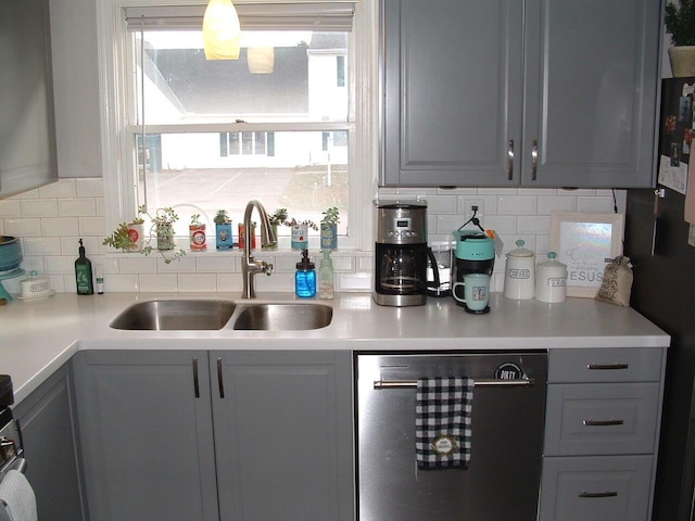 kitchen with stainless steel dishwasher, gray cabinetry, and sink