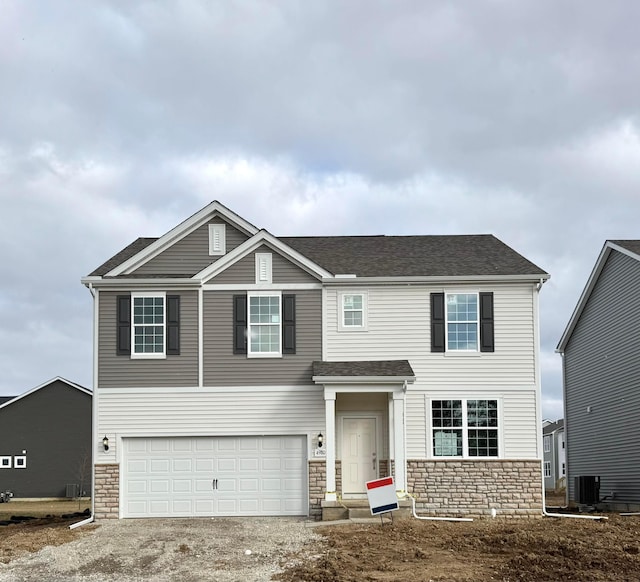 view of front of house with a garage, a shingled roof, dirt driveway, stone siding, and central air condition unit