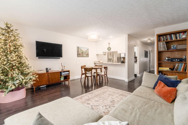 living room featuring dark wood-type flooring and a textured ceiling