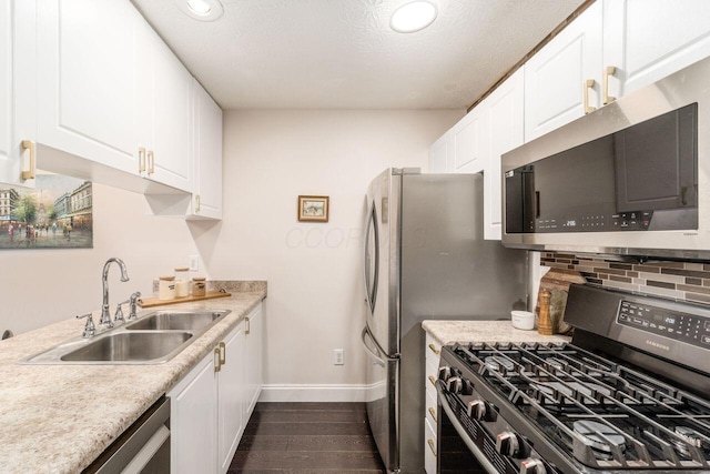 kitchen with sink, white cabinetry, stainless steel appliances, and dark wood-type flooring