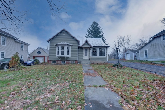 view of front of property with an outdoor structure, a front yard, and a garage