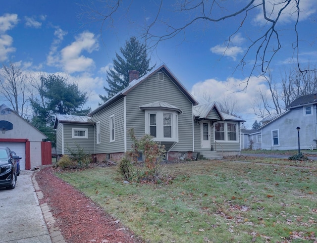 bungalow-style house with an outbuilding, a front yard, and a garage