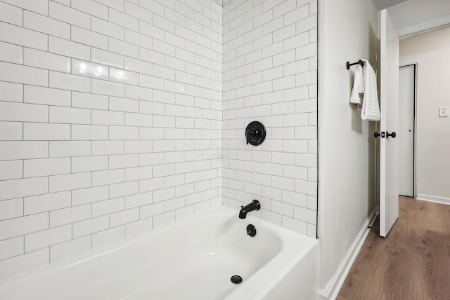 bathroom featuring tiled shower / bath combo and wood-type flooring