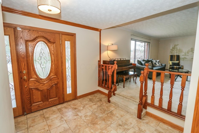 foyer entrance featuring a textured ceiling and crown molding