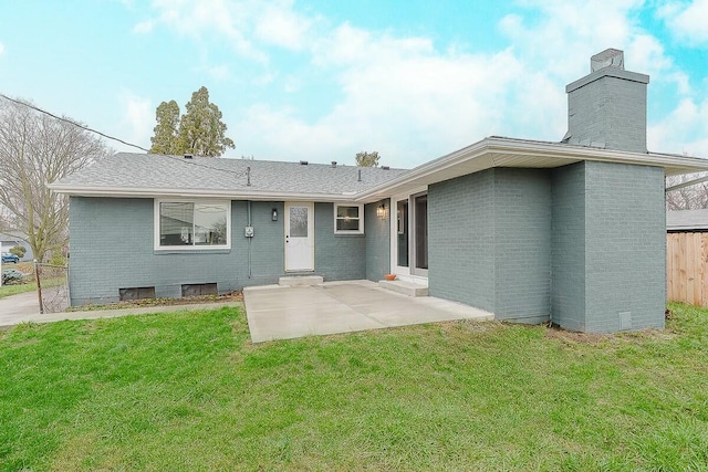 rear view of property with a lawn and a patio area