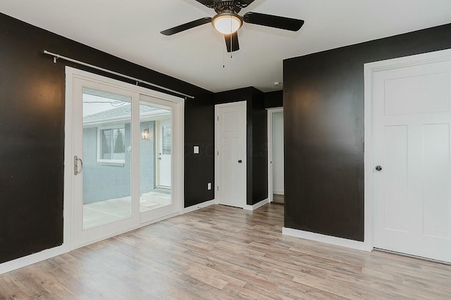 empty room with ceiling fan and light hardwood / wood-style floors