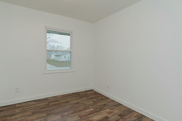 empty room with dark hardwood / wood-style flooring