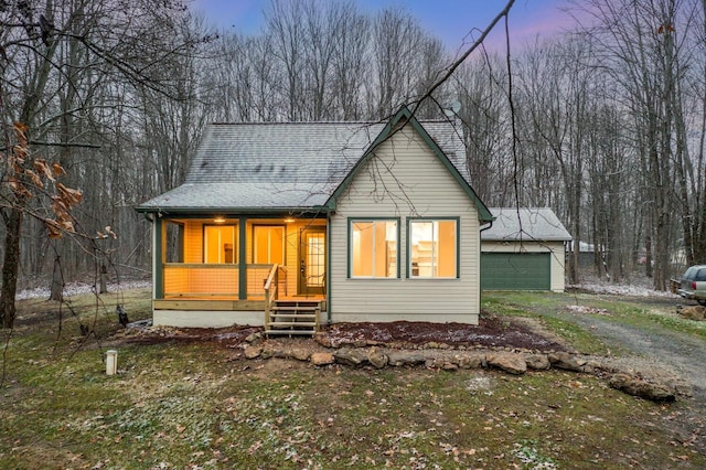 bungalow-style home featuring covered porch, an outdoor structure, and a garage