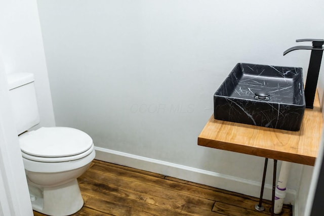 bathroom with toilet and hardwood / wood-style flooring