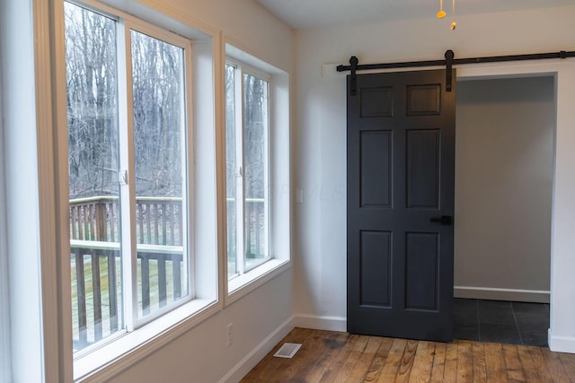 entryway featuring a barn door and dark hardwood / wood-style floors