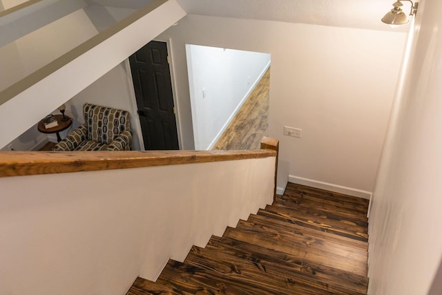 staircase with hardwood / wood-style floors and vaulted ceiling