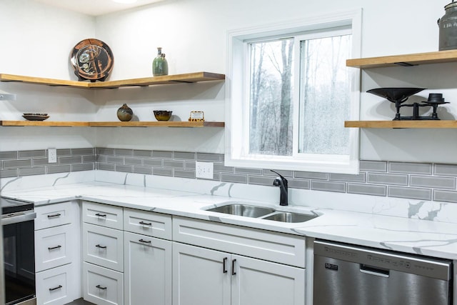 kitchen featuring light stone counters, sink, stainless steel appliances, and tasteful backsplash