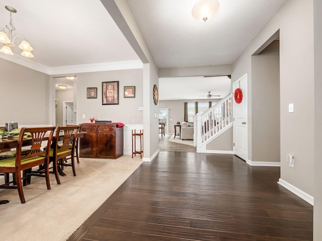 entryway featuring ceiling fan with notable chandelier, wood-type flooring, and crown molding