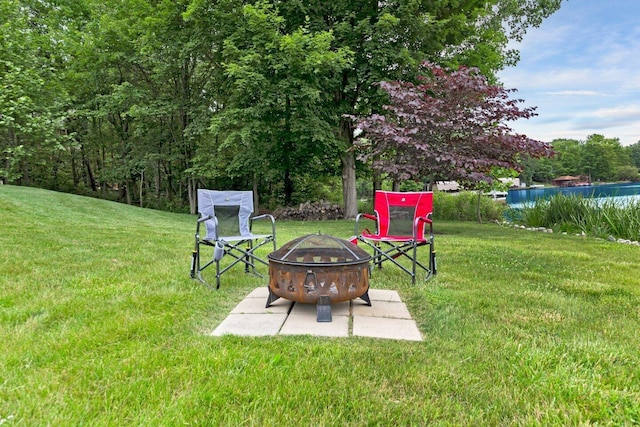 view of yard with a water view and an outdoor fire pit