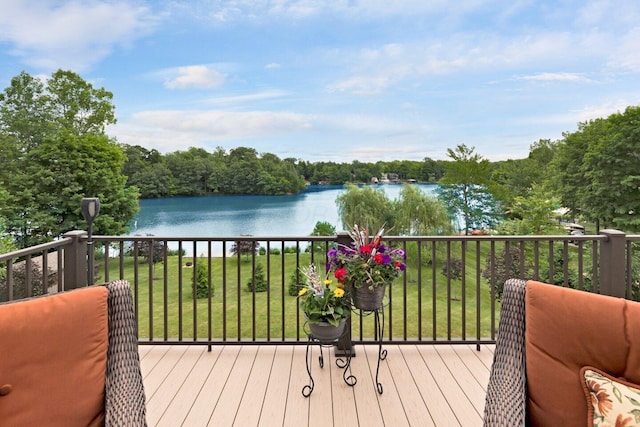 wooden terrace with a lawn and a water view