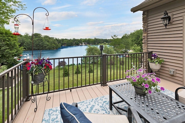 deck with a water view and a yard