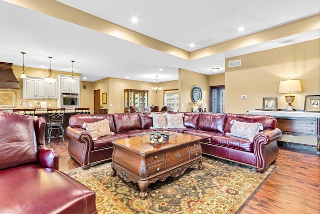 living room with wood-type flooring and an inviting chandelier