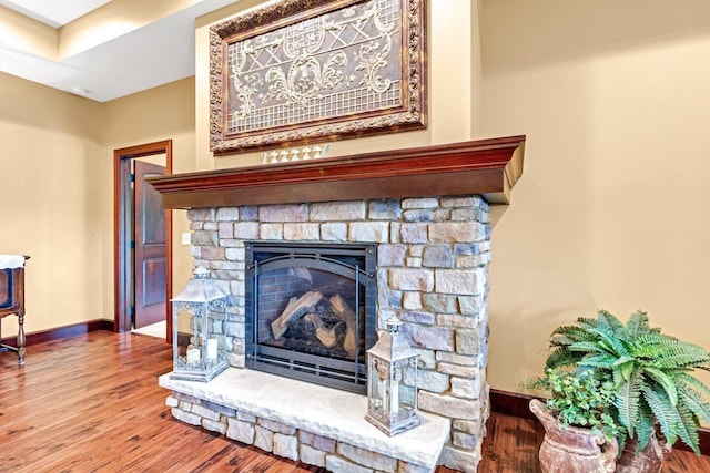 details featuring hardwood / wood-style flooring and a stone fireplace