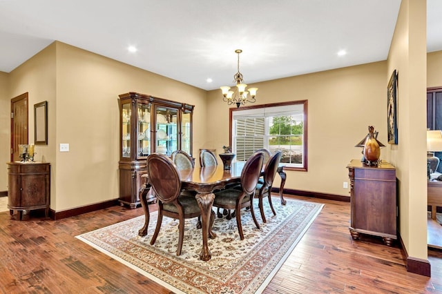 dining space with dark wood-type flooring and a chandelier