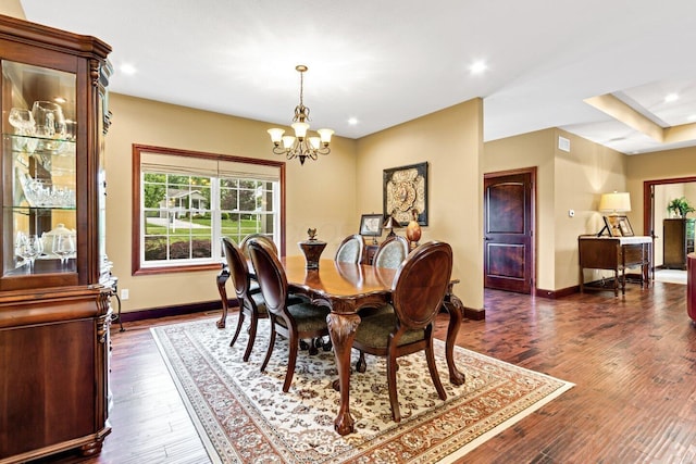 dining space featuring dark hardwood / wood-style floors and an inviting chandelier