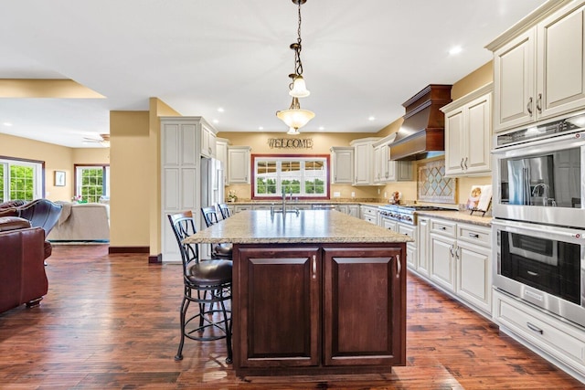 kitchen with a kitchen breakfast bar, dark hardwood / wood-style flooring, a center island, and pendant lighting