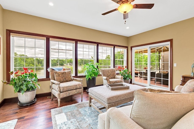 living room featuring ceiling fan and dark hardwood / wood-style floors