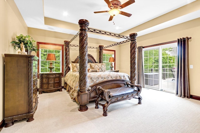 bedroom with access to outside, multiple windows, ceiling fan, and light colored carpet