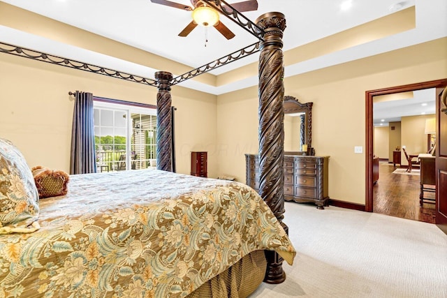 bedroom featuring access to outside, a raised ceiling, ceiling fan, and wood-type flooring