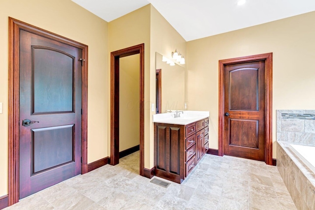 bathroom featuring vanity and tiled tub