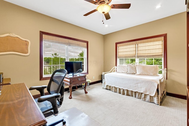 carpeted bedroom featuring multiple windows and ceiling fan