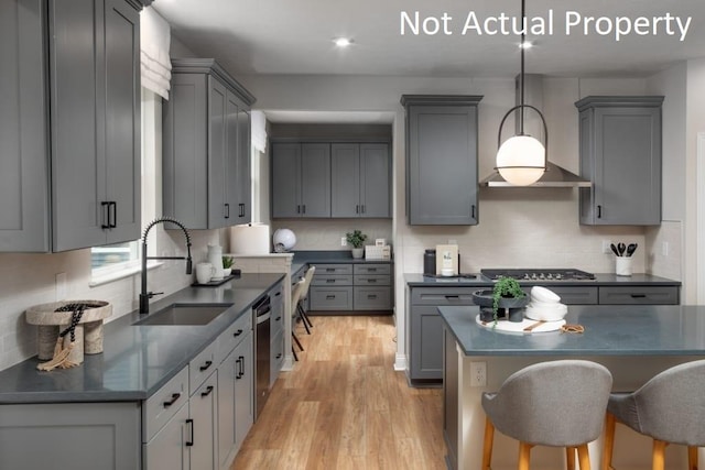 kitchen with decorative light fixtures, tasteful backsplash, sink, gray cabinetry, and stainless steel appliances