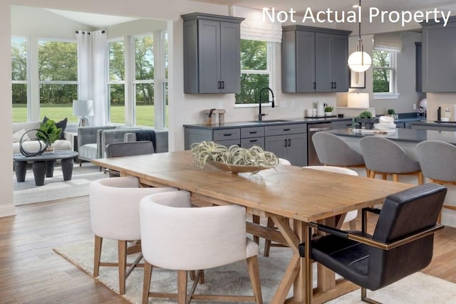 dining space with plenty of natural light, sink, and light hardwood / wood-style floors